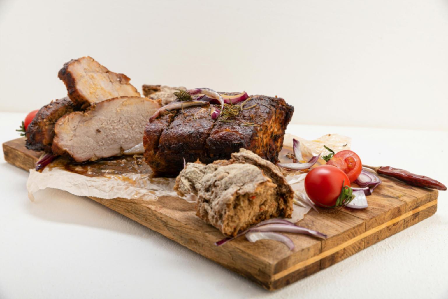 Students practicing knife techniques in a bright cooking studio